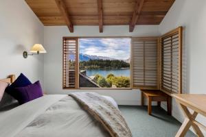 皇后镇Brunswick Lodge - Luxury - Central Queenstown的卧室设有湖景大窗户