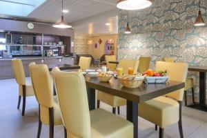 兰斯Sure Hotel by Best Western Reims Nord的用餐室配有桌椅和水果