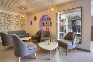 兰斯Sure Hotel by Best Western Reims Nord的一间设有桌椅和葡萄酒瓶的等候室