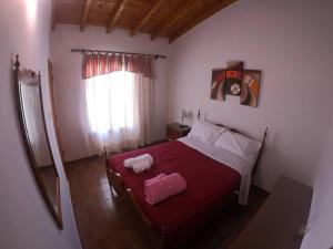 迈普Departamento encantador en Maipú的卧室配有红色的床,里面装有两只动物