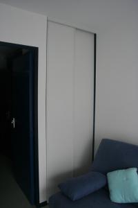 康博莱班甘德圭亚公寓的一张蓝色沙发,坐在一个大橱柜旁