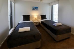 玛志洛太空度假公寓酒店的配有窗户的客房内的两张床