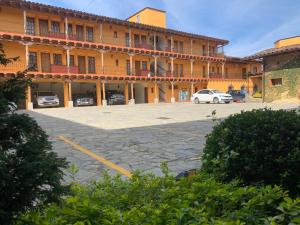 萨卡特兰波萨达唐拉蒙酒店的停车场内停放汽车的大型建筑