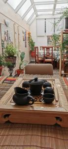 基多Sina Hogar Hotel 基多华人酒店的一张木托盘,桌上放着四个黑碗