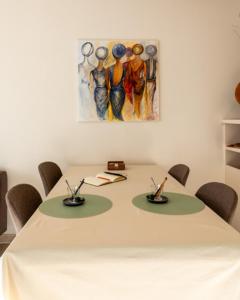 尼乌波特Apartment Casino的一张带椅子的白色桌子和墙上的一幅画