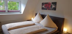 霍瓦赫特艾琳酒店的一间卧室配有带两个枕头的床和窗户