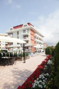 阳光海滩扎拉酒店的一座带庭院和鲜花的大型公寓大楼