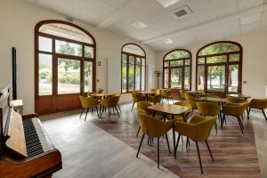 芒通圣贝尔纳花亭酒店的用餐室设有桌椅和窗户。