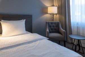 明登明登林佳特酒店 的配有一张床和一把椅子的酒店客房