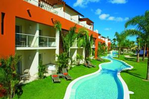 蓬塔卡纳Breathless Punta Cana Resort & Spa - Adults Only - All Inclusive的一座带游泳池的度假村,位于一座建筑旁边
