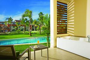 蓬塔卡纳Breathless Punta Cana Resort & Spa - Adults Only - All Inclusive的带浴缸的浴室,享有游泳池的景色