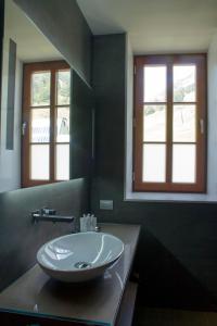 克拉尔夫斯户撒努里亚山谷酒店的一间带水槽的浴室和两个窗户