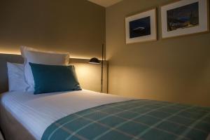 克拉尔夫斯户撒努里亚山谷酒店的一间卧室配有一张带蓝色枕头的床
