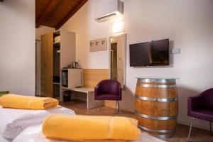 德罗玛索阿格里图尔圣露西亚酒店的一间设有酒桶和两把紫色椅子的房间