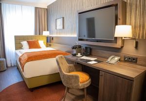 埃森Hotel Essener Hof; Sure Hotel Collection by Best Western的酒店客房配有一张床和一张书桌及一台电视