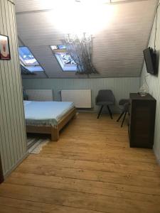布克维Chalet Blanc的一间卧室配有一张床、一张书桌和两个窗户。