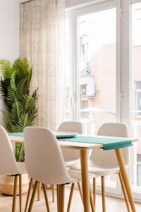 格拉纳达Apartamento Nuevo Centro Granada的一间带桌子和白色椅子的用餐室