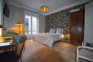 兰斯阿祖尔酒店的一间卧室配有一张带花卉壁纸的床