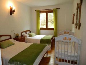奥查加维亚Casa Rural Mantxoalorra的一间卧室设有两张床、一个窗口和一张婴儿床。