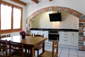 奥查加维亚Casa Rural Mantxoalorra的一间带木桌的厨房和一间餐厅