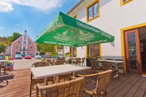 SiegenburgGasthof Postbräu的室外餐厅设有桌椅和遮阳伞。
