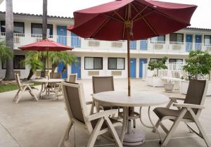 卡马里奥卡马里奥6号汽车旅馆的一个带桌椅和遮阳伞的庭院。