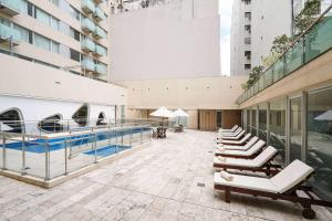 布宜诺斯艾利斯雷科莱塔眩晕酒店的一座带游泳池和躺椅的建筑