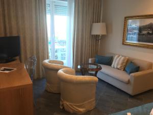 阿拉西奥美帝特拉奈大酒店的客厅配有沙发、椅子和电视