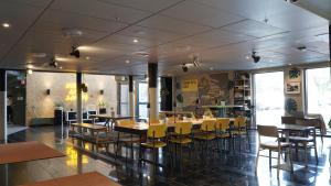 马尔默马尔默康福特茵酒店的用餐室配有桌子和黄色椅子