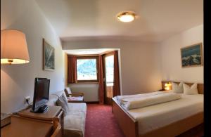 皮茨河谷圣莱昂哈德匹兹酒店的酒店客房配有一张床和一张书桌及一台电视