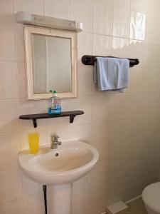 桑当艾塔维亚酒店的一间带水槽、镜子和卫生间的浴室