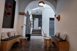 圣路易斯Ndar Ndar House的带2张长椅的客房和带楼梯的走廊