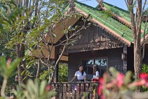 素可泰Thai Thai Sukhothai Resort的两人站在房子的阳台上