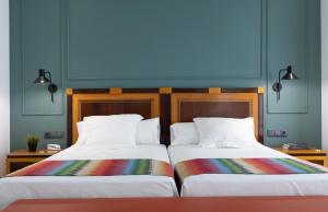 马拉加邓卡罗酒店的两张睡床彼此相邻,位于一个房间里