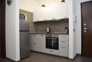 塞斯托-圣乔凡尼Ginevra Home的厨房配有白色橱柜和冰箱。