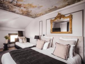 拉罗谢尔Maisons du Monde Hôtel & Suites - La Rochelle Vieux Port的一间卧室配有一张大床和镜子
