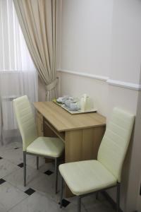 索契索科尔酒店的配有桌子和两把椅子以及桌椅的房间
