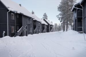 萨伦Vasabyn Fjällhem的一些建筑前的一条雪覆盖的街道