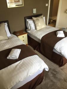 斯凯格内斯Woodthorpe Hotel的酒店客房,配有两张带毛巾的床