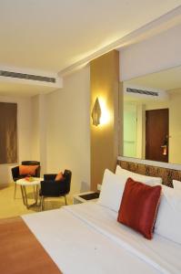 日惹日惹比利牛斯酒店的配有一张床和一把椅子的酒店客房