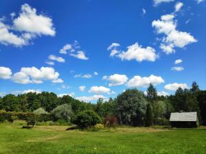 尤卡尔内Lūķi, Lauku sēta的一片带长凳的公园,一片蓝天,云朵