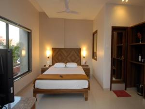 舍地Sai Palace Budget Hotel的一间卧室设有一张床和一个大窗户