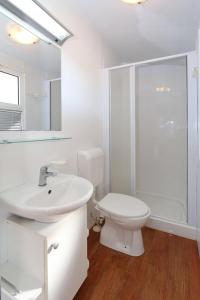 图兰杰Poolside Mobile Home的白色的浴室设有卫生间和水槽。