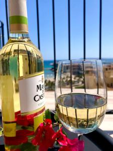 阿利坎特View 4 U Apartment - Alicante的玻璃杯旁的一瓶葡萄酒