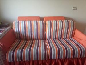 艾因苏赫纳One Bedroom Chalet at Porto South Beach Families only的一把椅子,在房间里有一个橙色的条纹座位