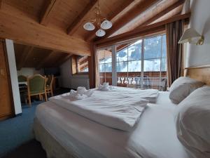 基茨比厄尔附近奥拉赫Ferienhotel Alpenhof的一张大白色的床,位于一个设有大窗户的房间