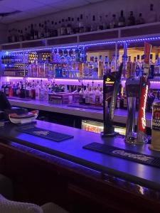 布莱克浦The Melville Hotel - Central Location的酒吧配有带酒精饮品的蓝色台面
