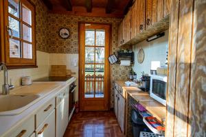 LathuilleLe Chalet Soleil的厨房配有木制橱柜、水槽和门