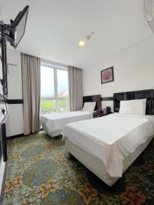 新加坡The Snooze Hotel Marine Parade的酒店客房设有两张床和窗户。