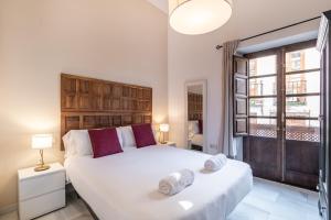 格拉纳达BnS Dauro Suites的卧室设有一张白色大床和一扇窗户。